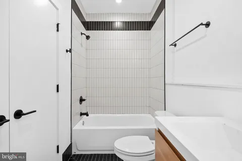 a bathroom with a bathtub shower sink vanity and toilet