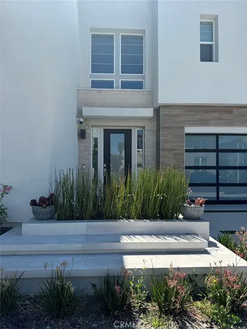 a front view of a house with plants