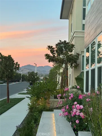 a front view of a house with a yard and fountain in middle