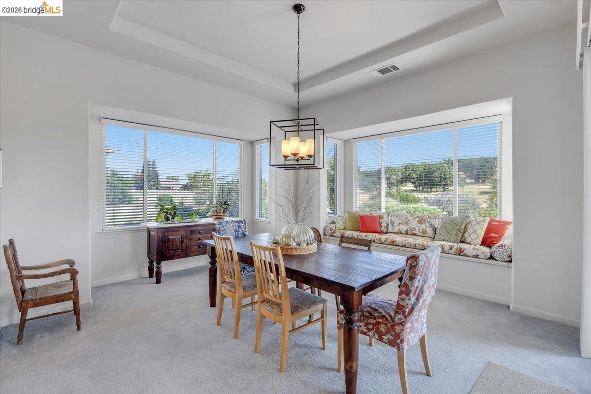 258 Rock Ridge Lane Copperopolis, CA 95228 - Photo 26 of 47 Dining room with a raised ceiling, suspended lighting, and light colored carpet