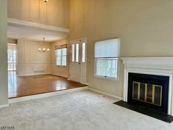 an empty room with windows and fireplace