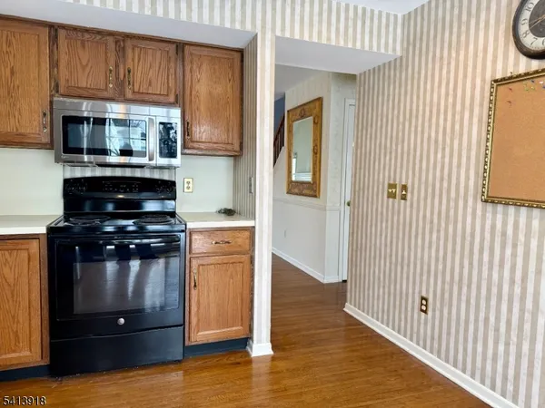 a kitchen with stainless steel appliances wooden cabinets and a stove top oven
