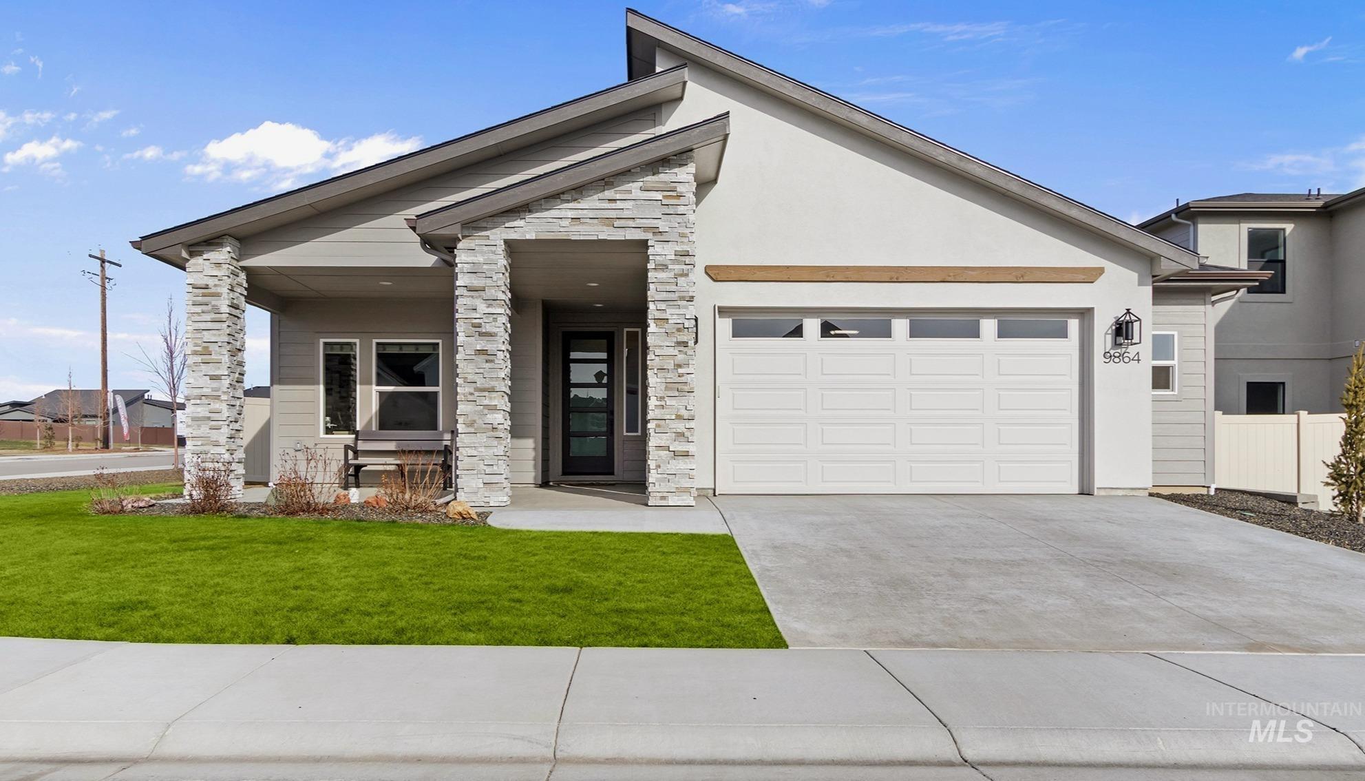 9864 West Aviara Street Star, ID 83669 - Photo 1 of 40 View of front of property featuring stone siding, driveway, stucco siding, an attached garage, and a porch