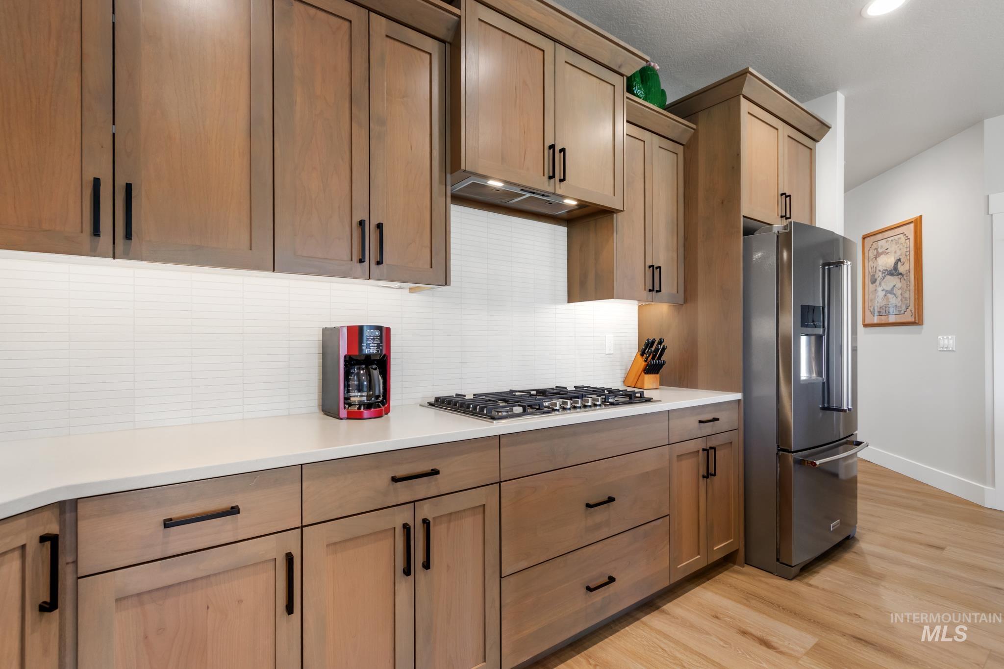 9864 West Aviara Street Star, ID 83669 - Photo 16 of 40 Kitchen featuring stainless steel appliances, backsplash, and light wood-type flooring