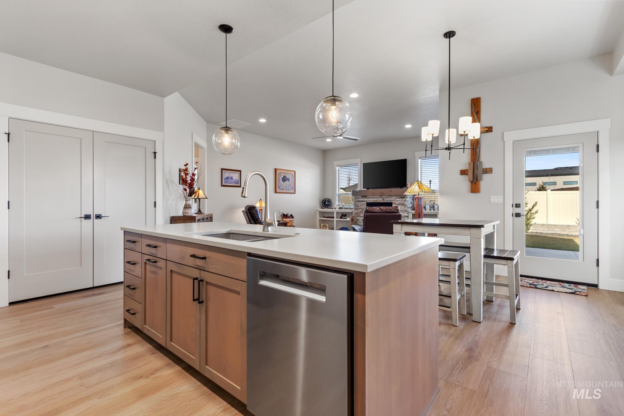 9864 West Aviara Street Star, ID 83669 - Photo 40 of 40 Kitchen with dishwasher, a center island with sink, light wood-type flooring, decorative light fixtures, and open floor plan