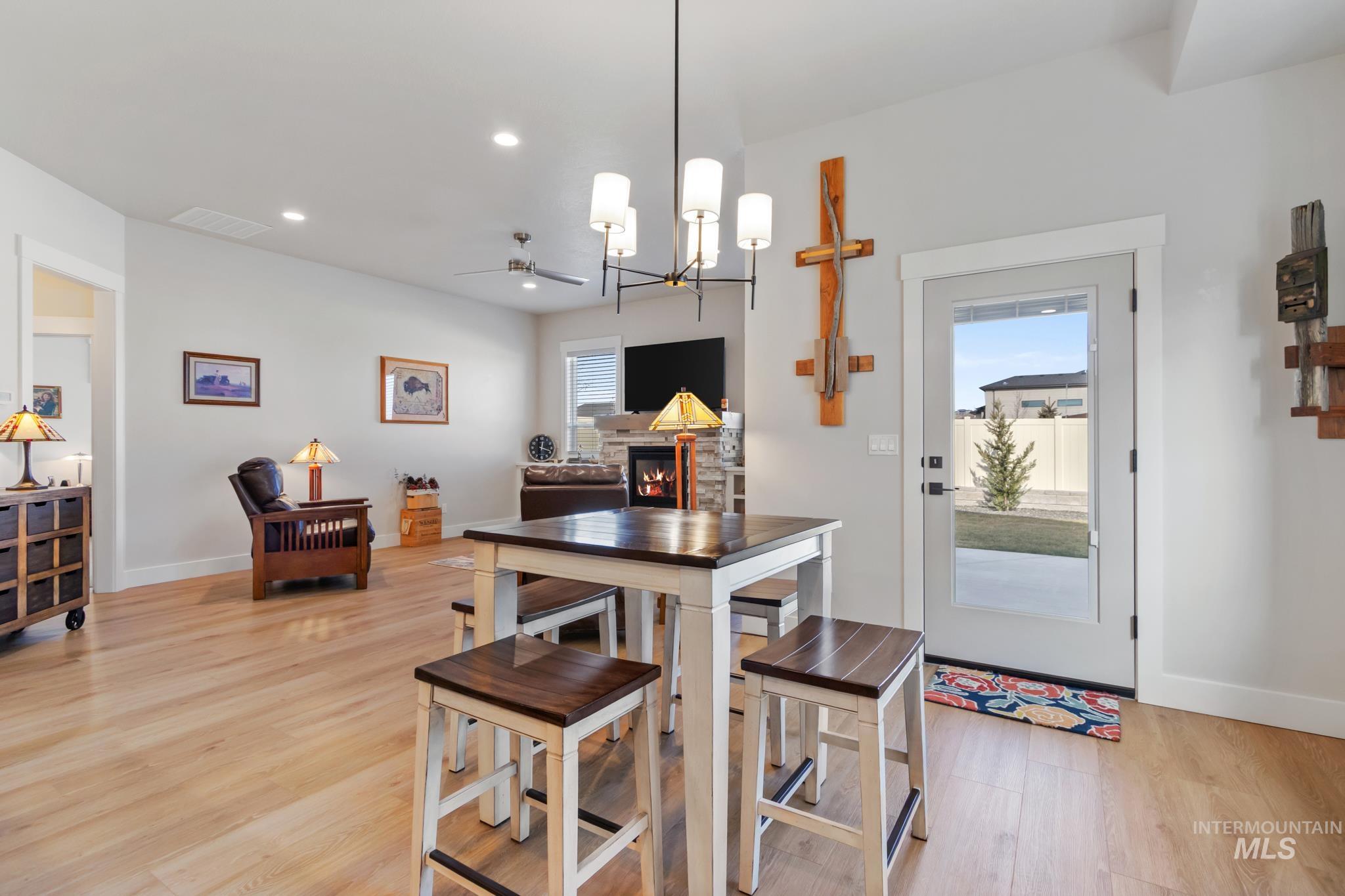 9864 West Aviara Street Star, ID 83669 - Photo 18 of 40 Dining area featuring light wood-type flooring, hanging lights, and a stone fireplace