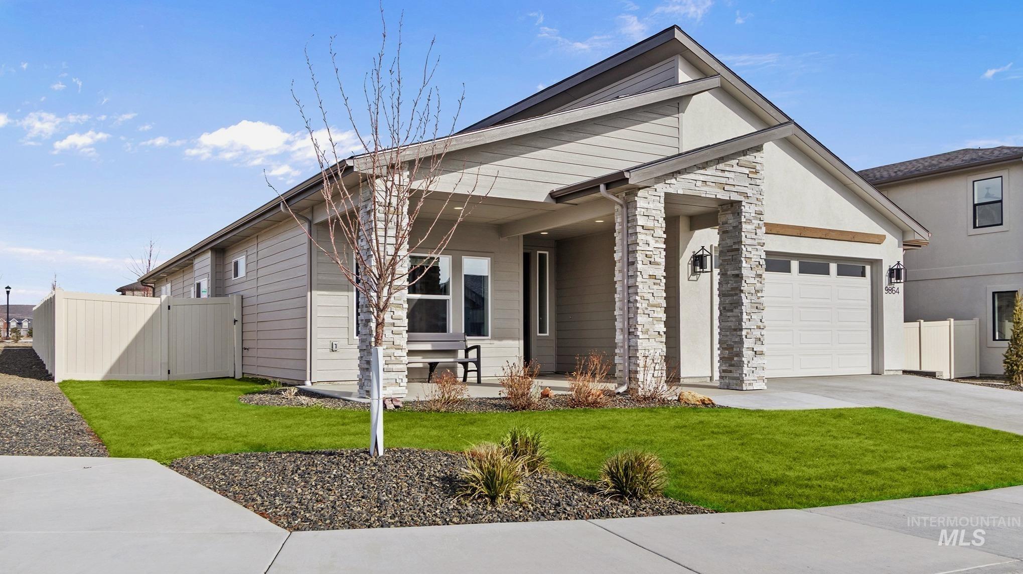 9864 West Aviara Street Star, ID 83669 - Photo 2 of 40 View of front of home with a gate, stone siding, concrete driveway, stucco siding, and a garage