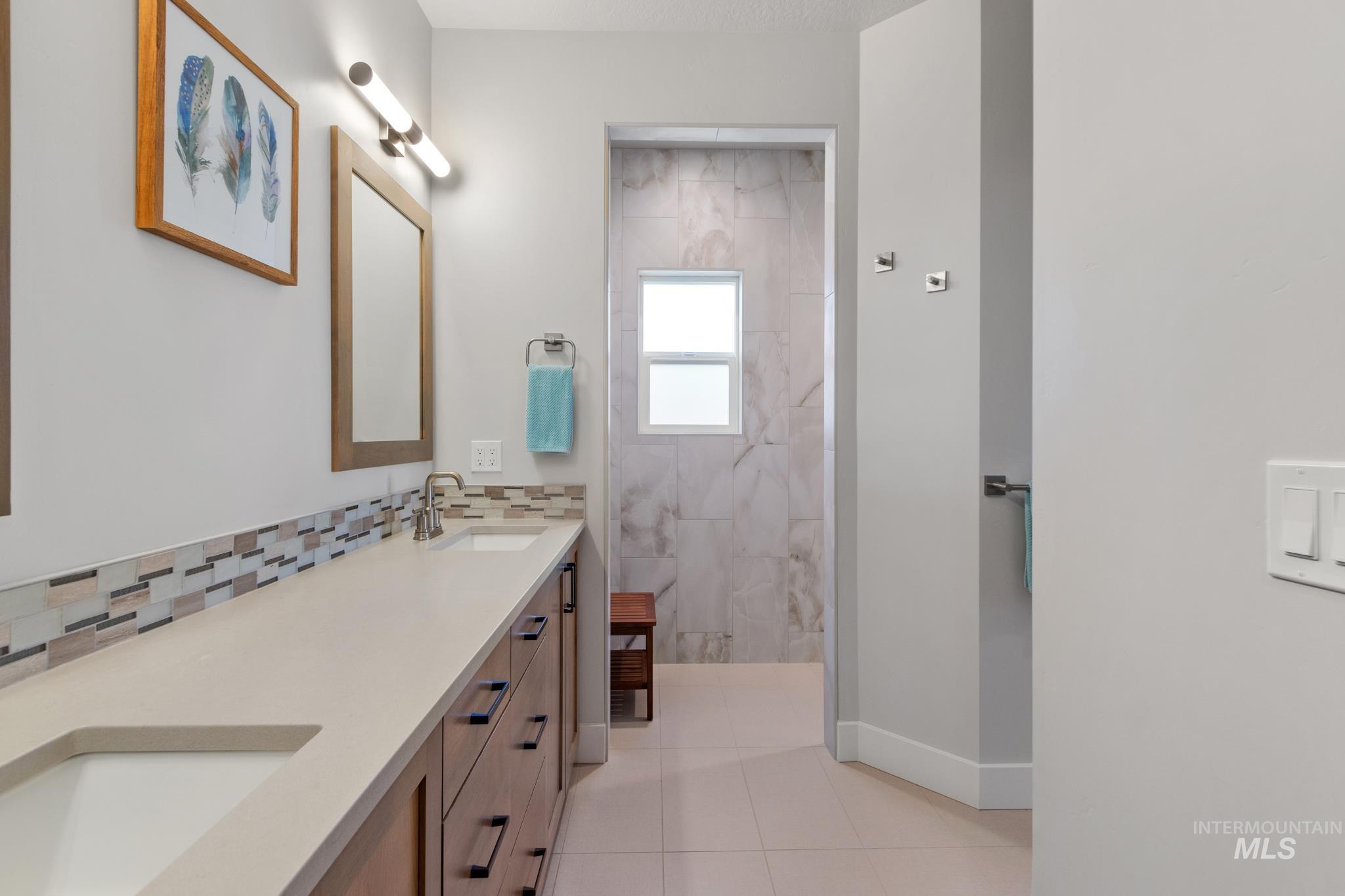 9864 West Aviara Street Star, ID 83669 - Photo 30 of 40 Bathroom with a marble finish shower, double vanity, and light tile patterned flooring