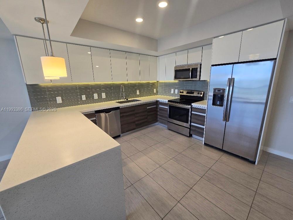 117 Southwest 10th Street, Unit 2105 Miami, FL 33130 - Photo 10 of 18 a kitchen with stainless steel appliances a stove a sink a microwave a refrigerator a counter top space and cabinets