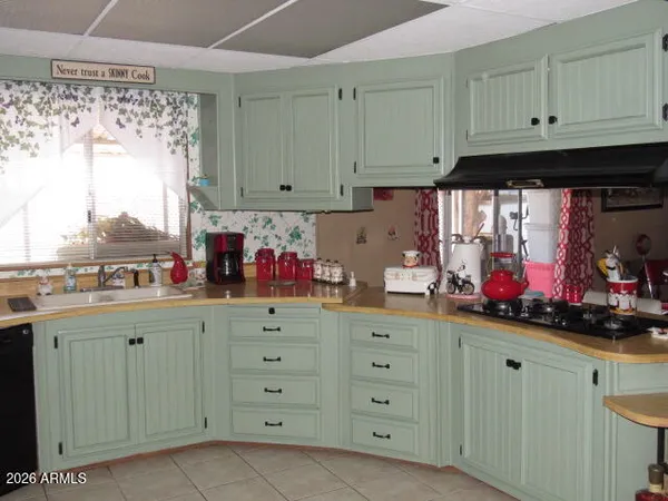 a kitchen with granite countertop a sink window and cabinets