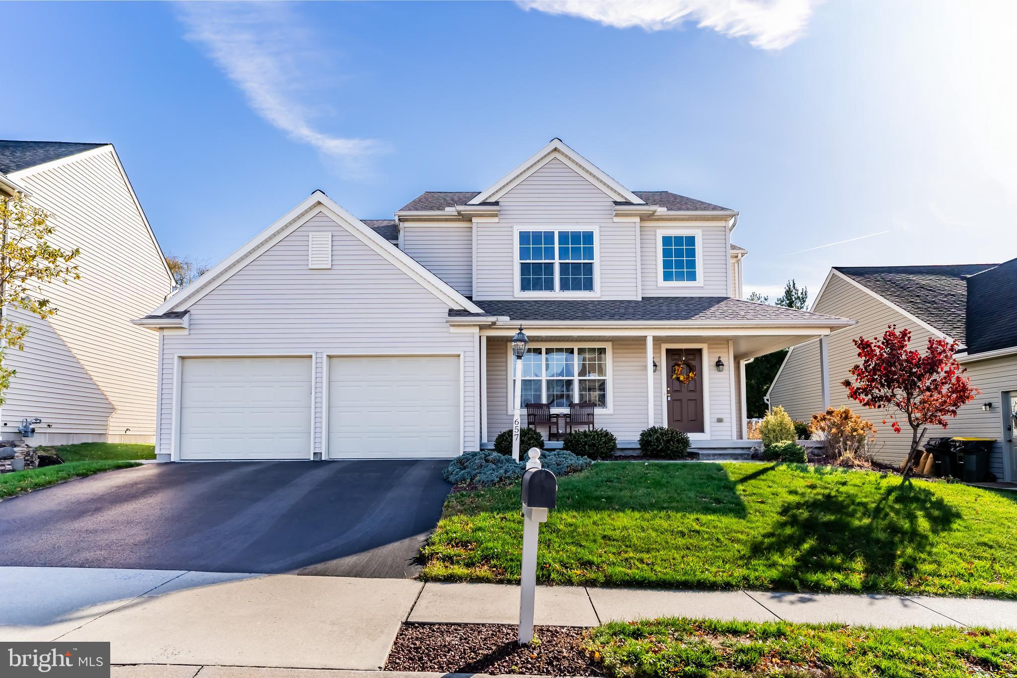 a front view of a house with a yard and potted plants