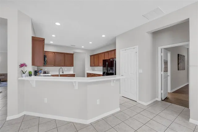 a kitchen with stainless steel appliances granite countertop a refrigerator a stove top oven a sink dishwasher and wooden cabinets