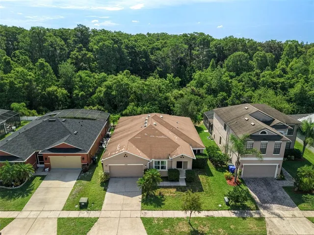 an aerial view of residential houses with outdoor space and trees