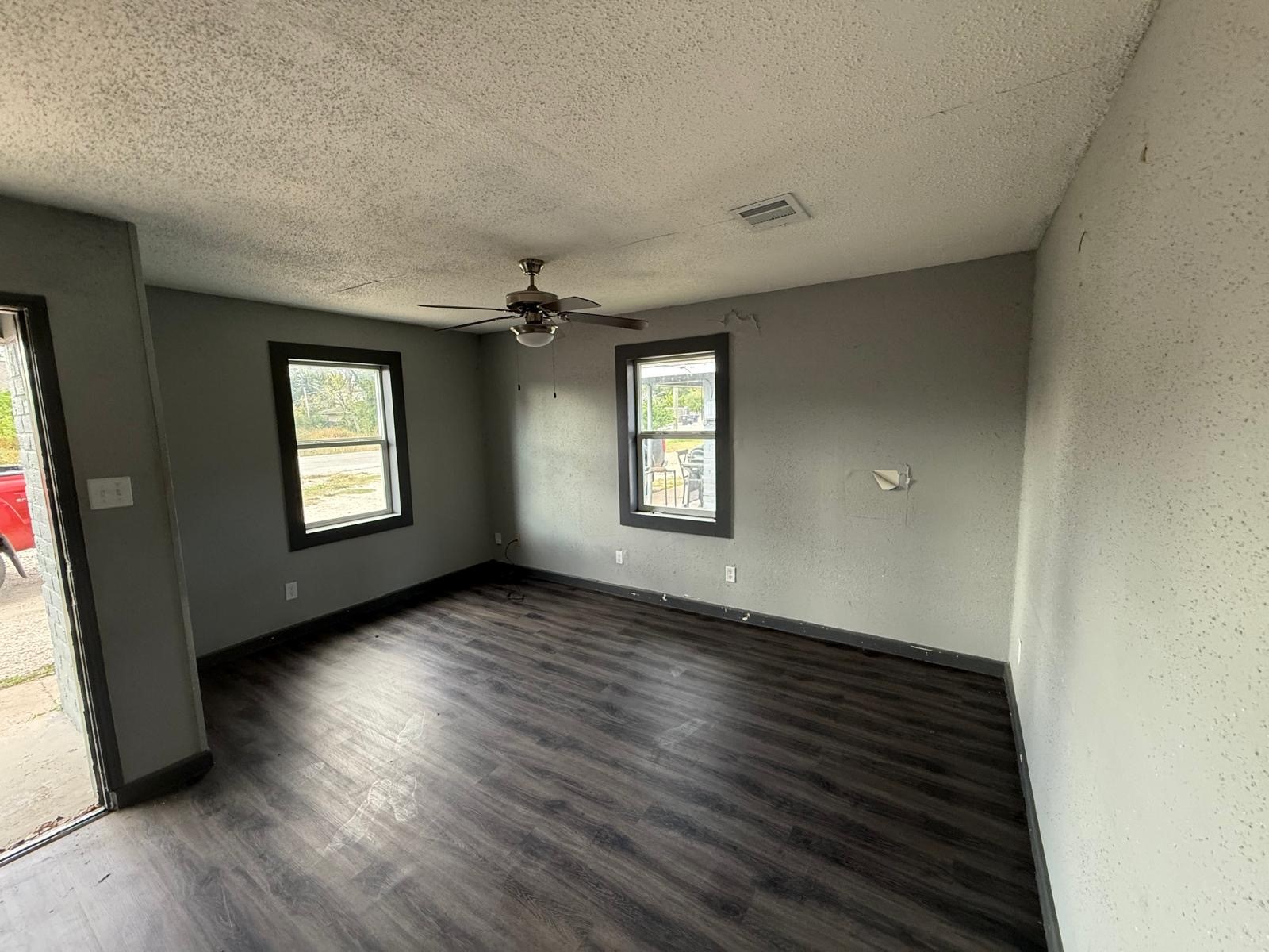 9045 Jutland Road Houston, TX 77033 - Photo 2 of 11 an empty room with wooden floor and windows