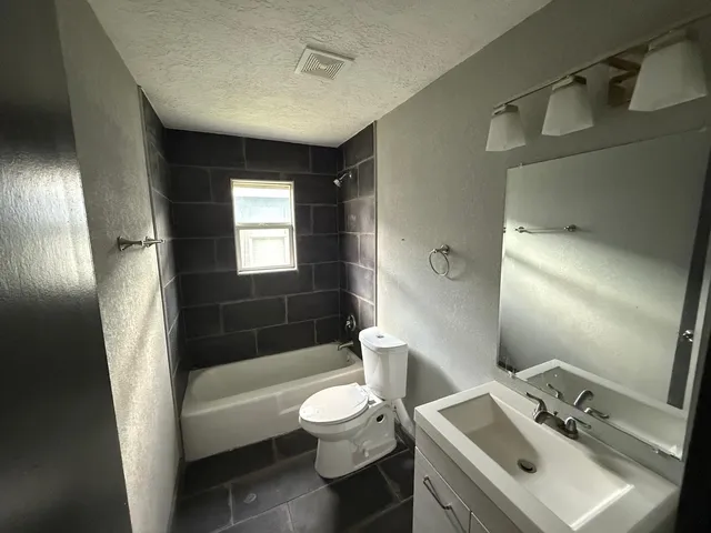 a bathroom with a sink toilet tub and shower