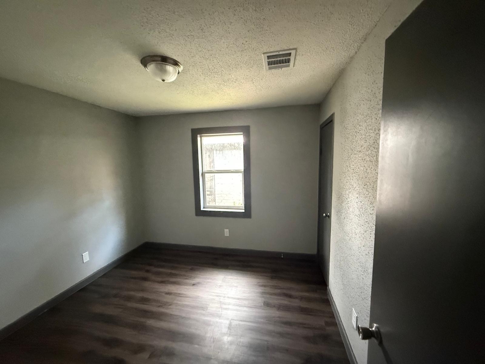9045 Jutland Road Houston, TX 77033 - Photo 8 of 11 an empty room with wooden floor and windows