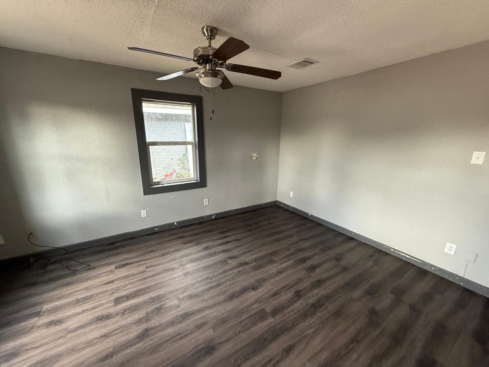 9045 Jutland Road Houston, TX 77033 - Photo 10 of 11 a view of empty room with wooden floor and fan