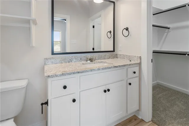 a bathroom with a granite countertop sink a toilet and a bathtub