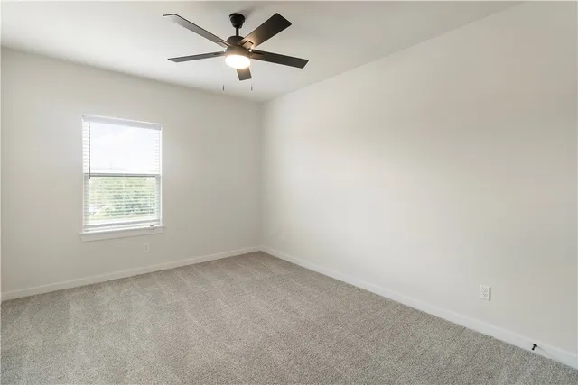 an empty room with chandelier fan
