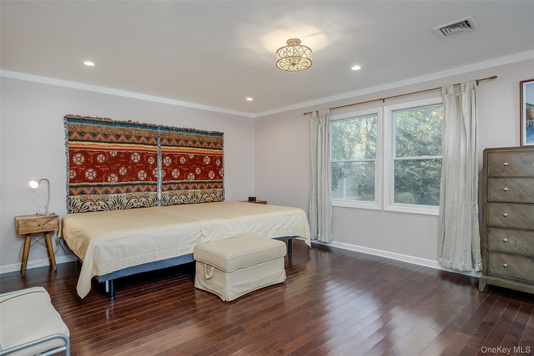 3 Earl Road Melville, NY 11747 - Photo 16 of 35 a large bedroom with a bed and wooden floor