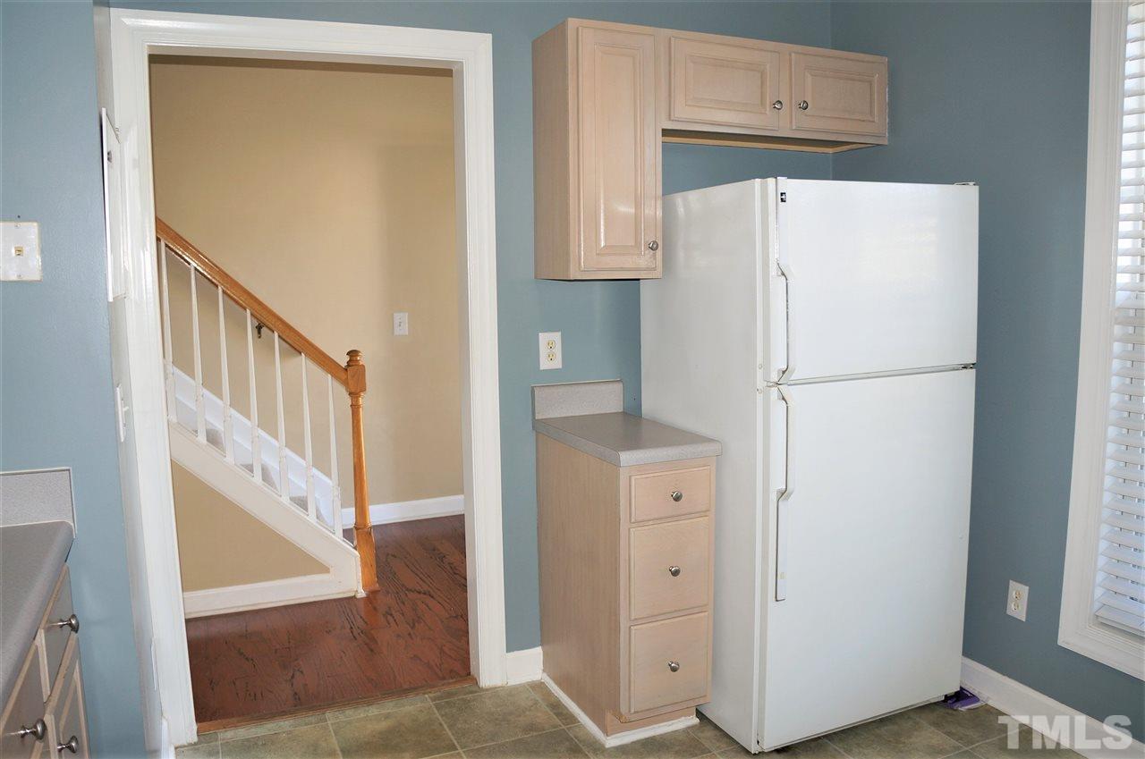 9204 Grassington Way Raleigh, NC 27615 - Photo 11 of 29 a white refrigerator freezer and a microwave sitting in a kitchen