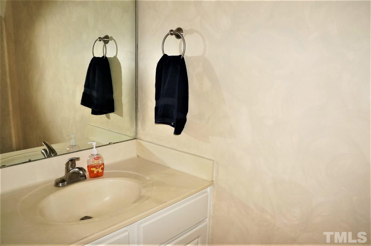 9204 Grassington Way Raleigh, NC 27615 - Photo 13 of 29 a bathroom with a sink and mirror