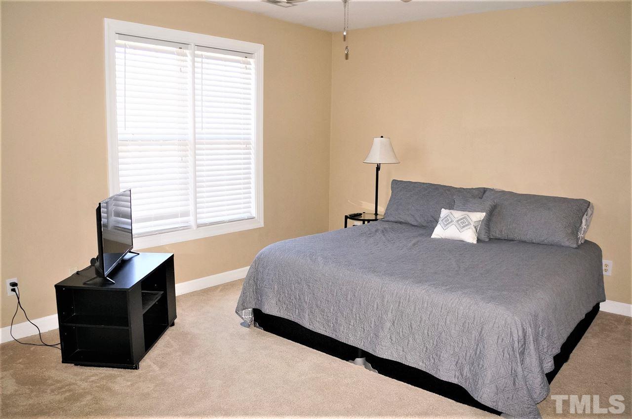 9204 Grassington Way Raleigh, NC 27615 - Photo 16 of 29 a bedroom with a bed and wooden floor