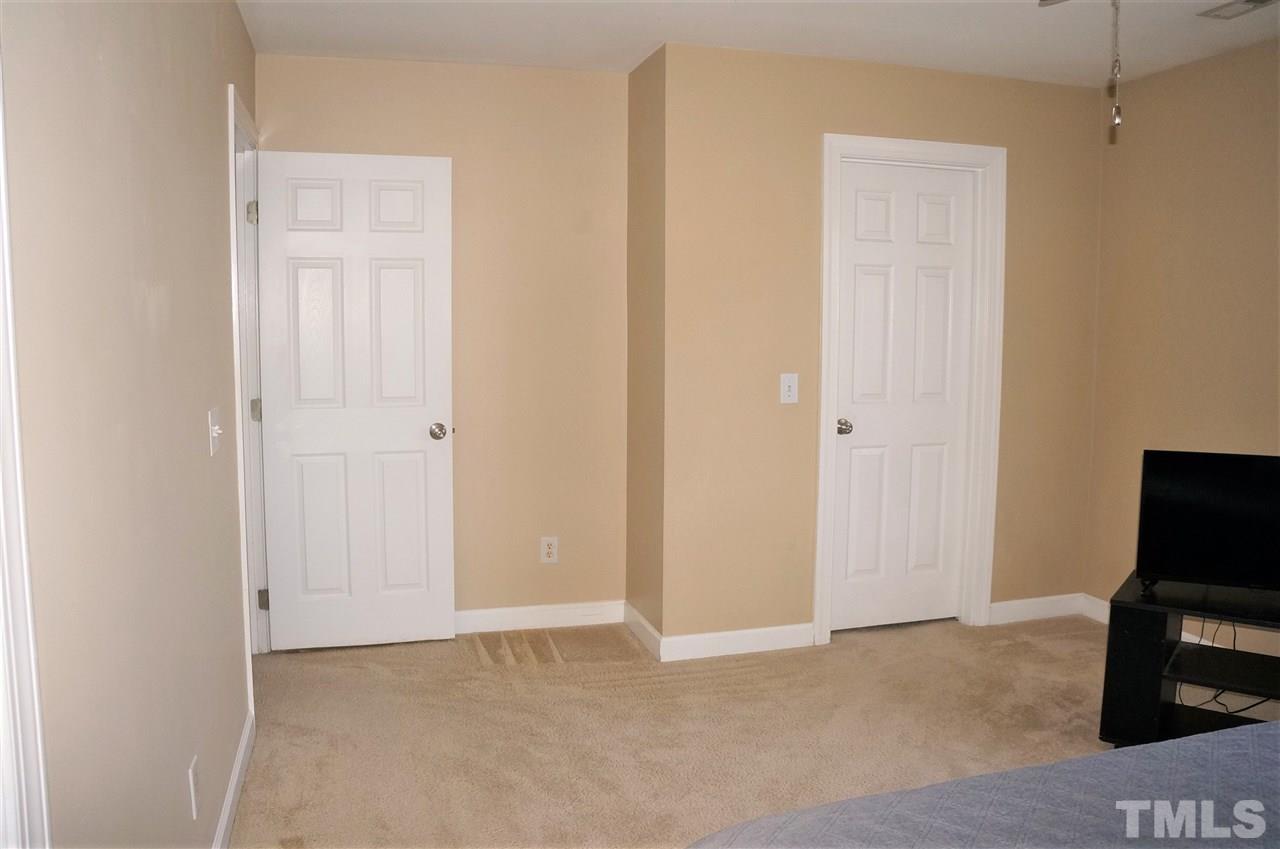 9204 Grassington Way Raleigh, NC 27615 - Photo 19 of 29 a view of room with walk in closet and wooden cabinets