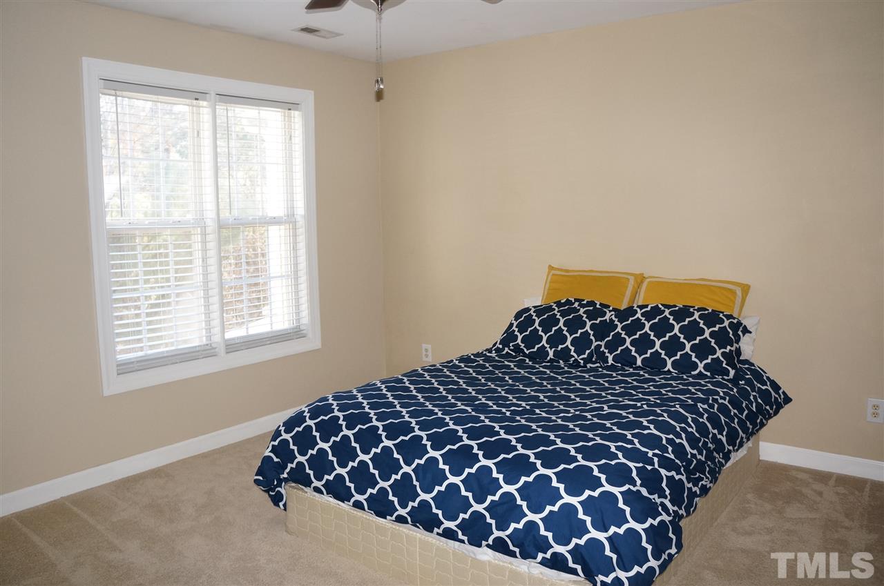 9204 Grassington Way Raleigh, NC 27615 - Photo 22 of 29 a bed sitting in a bedroom next to a window