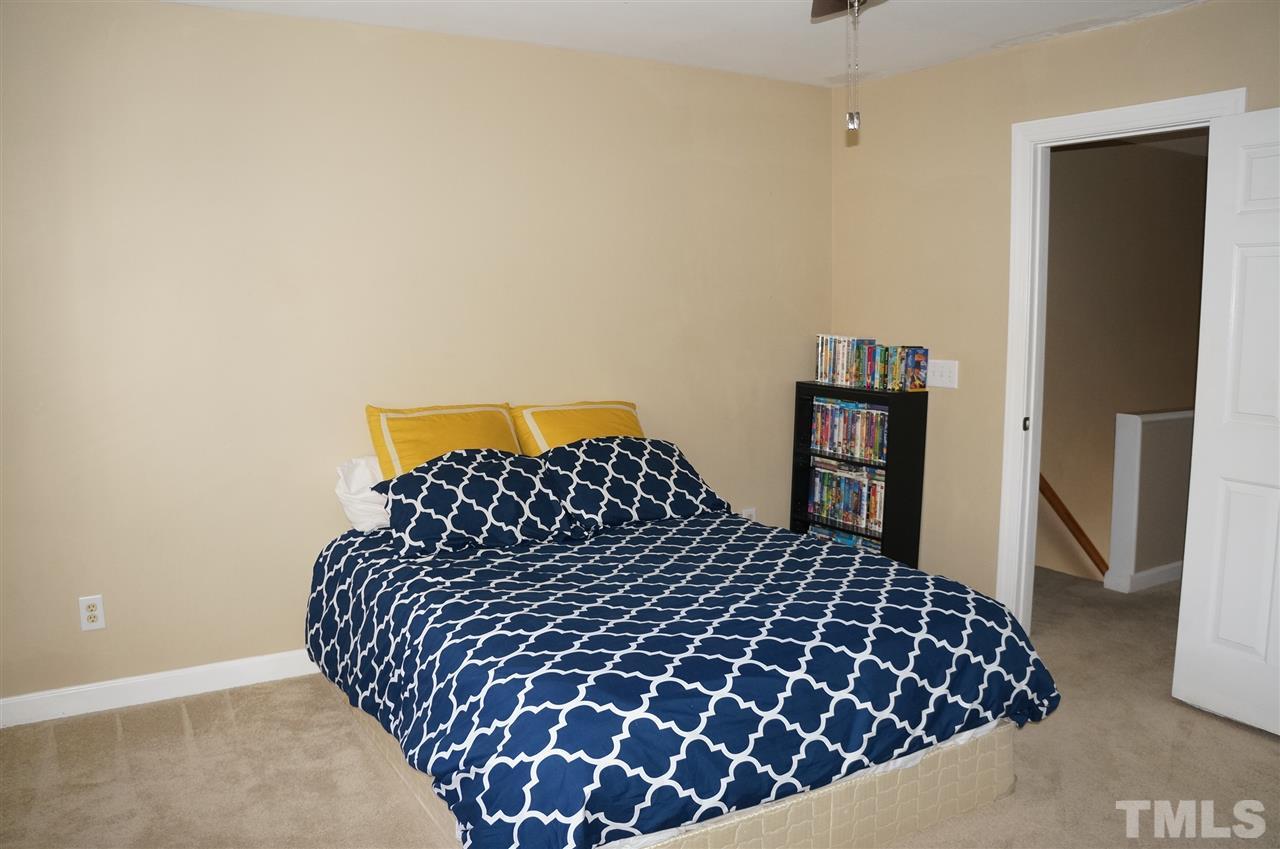 9204 Grassington Way Raleigh, NC 27615 - Photo 24 of 29 a large bed sitting in a bedroom next to a cabinet