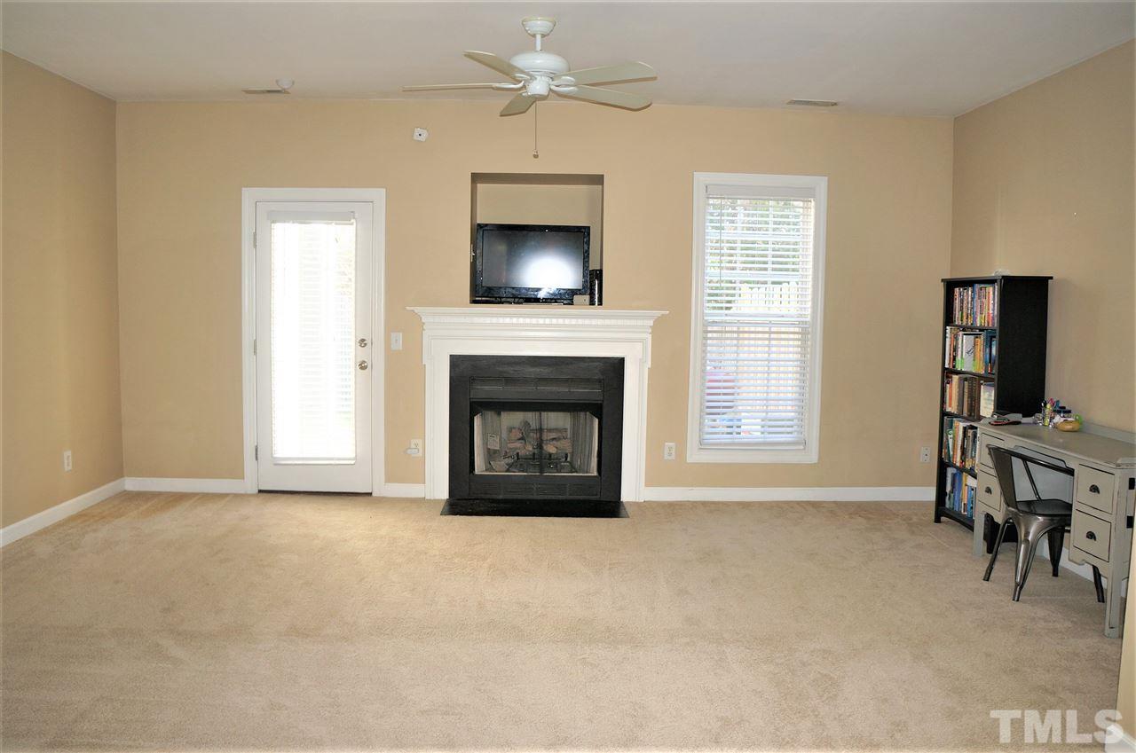 9204 Grassington Way Raleigh, NC 27615 - Photo 4 of 29 a view of an empty room with a fireplace and a window
