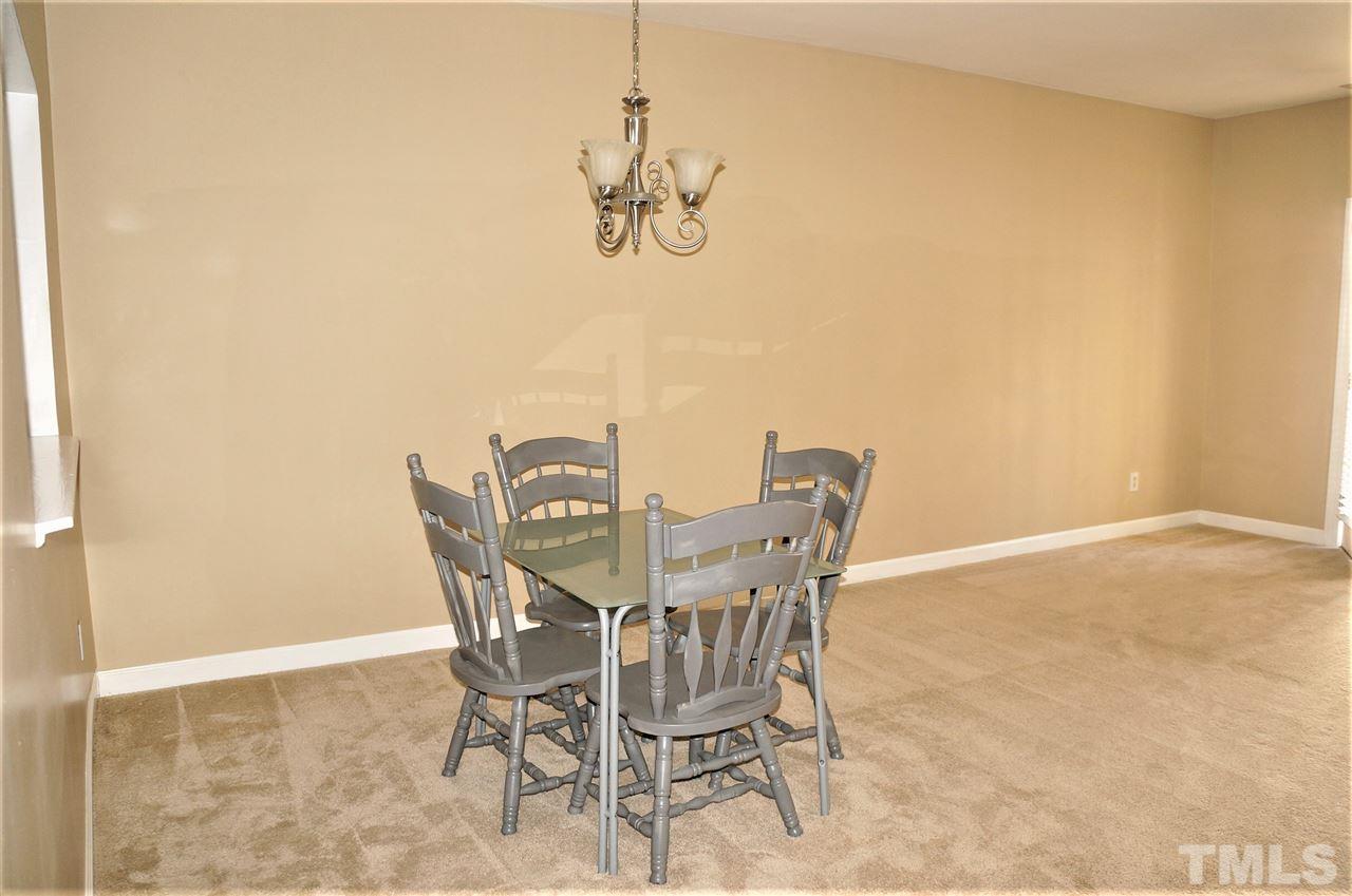 9204 Grassington Way Raleigh, NC 27615 - Photo 5 of 29 a view of a dining room with furniture and a chandelier