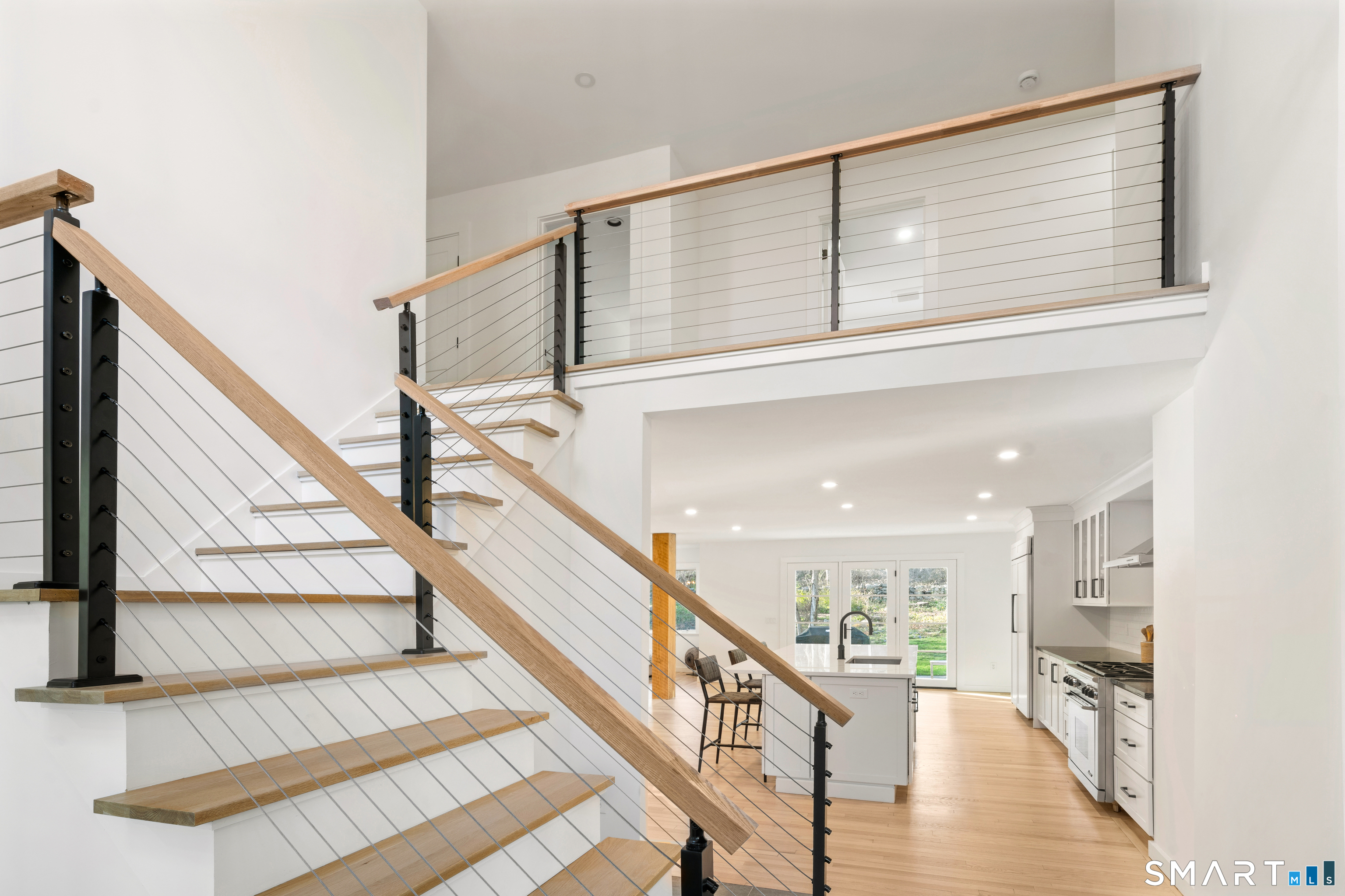 23 Norton Road Easton, CT 06612 - Photo 3 of 40 The foyer makes a strong first impression with its cable rail staircase and open two story design, drawing the eye upward and through to the patio beyond.