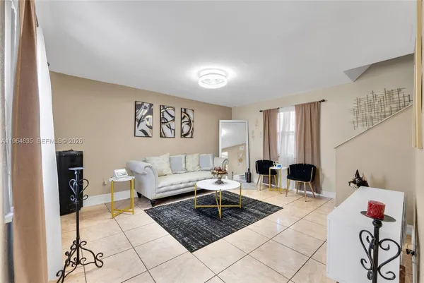 a living room with furniture a rug and a window