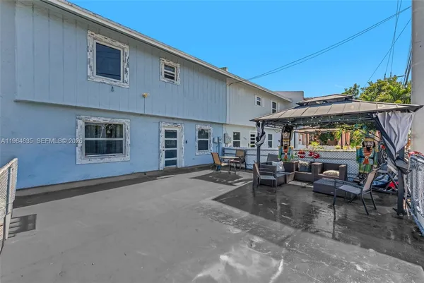 a view of a patio with table and chairs under an umbrella