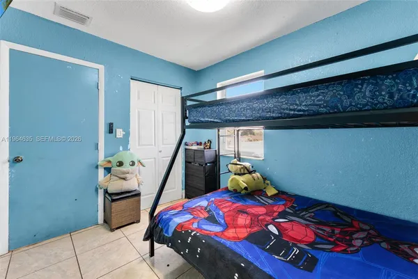 a bedroom with bed and wooden floor