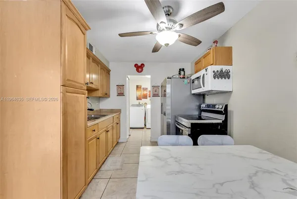 a kitchen with stainless steel appliances a stove top oven a refrigerator a sink and dishwasher