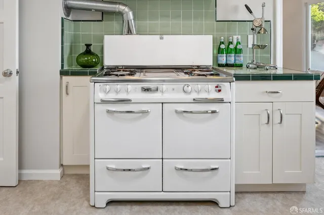 a kitchen with a stove a refrigerator and a dining table