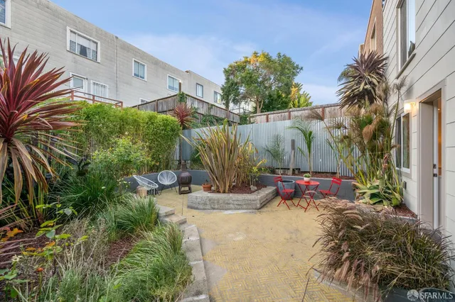 a view of outdoor sitting area with furniture and wooden fence