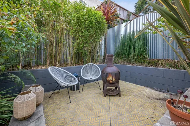a backyard of a house with table and chairs potted plants and outdoor seating