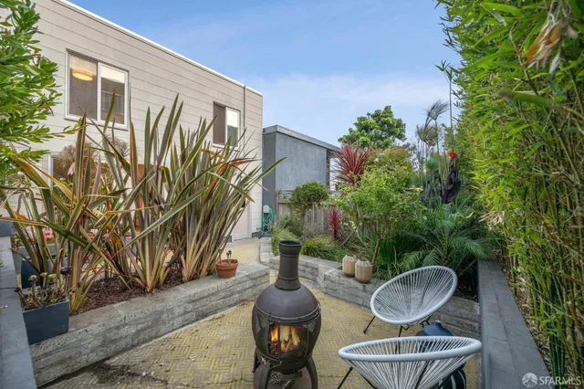 a view of a backyard with sitting area and garden