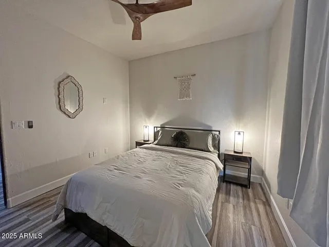 a bedroom with a bed and wooden floor