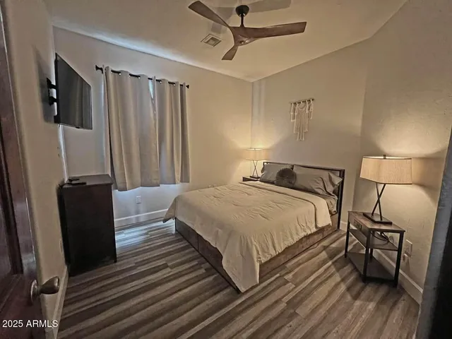 a bedroom with a bed wooden floor and a desk