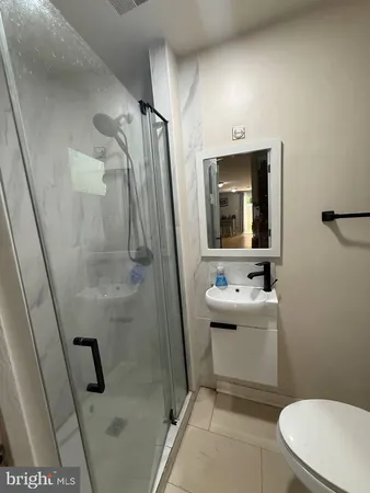 a bathroom with a sink a toilet and mirror