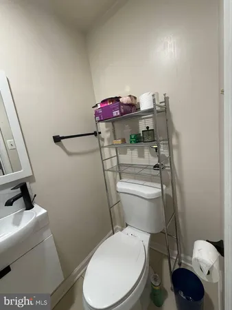 a white toilet sitting next to a bathroom sink and vanity