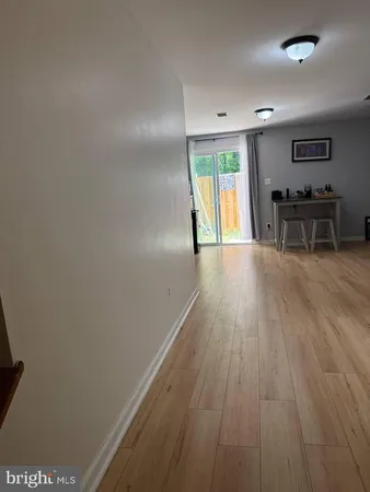 a view of an empty room with window and wooden floor