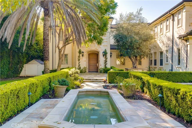 a view of a door of the house with potted plants