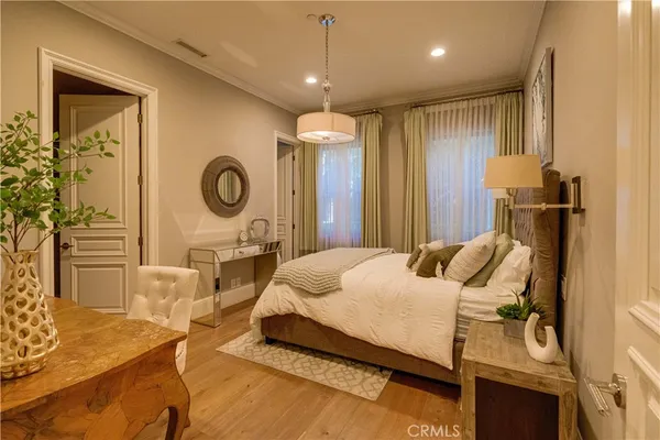 a spacious bedroom with a balcony a bed and wooden floor