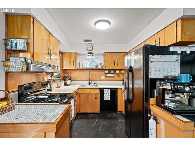 a kitchen with kitchen island granite countertop a sink cabinets and stainless steel appliances