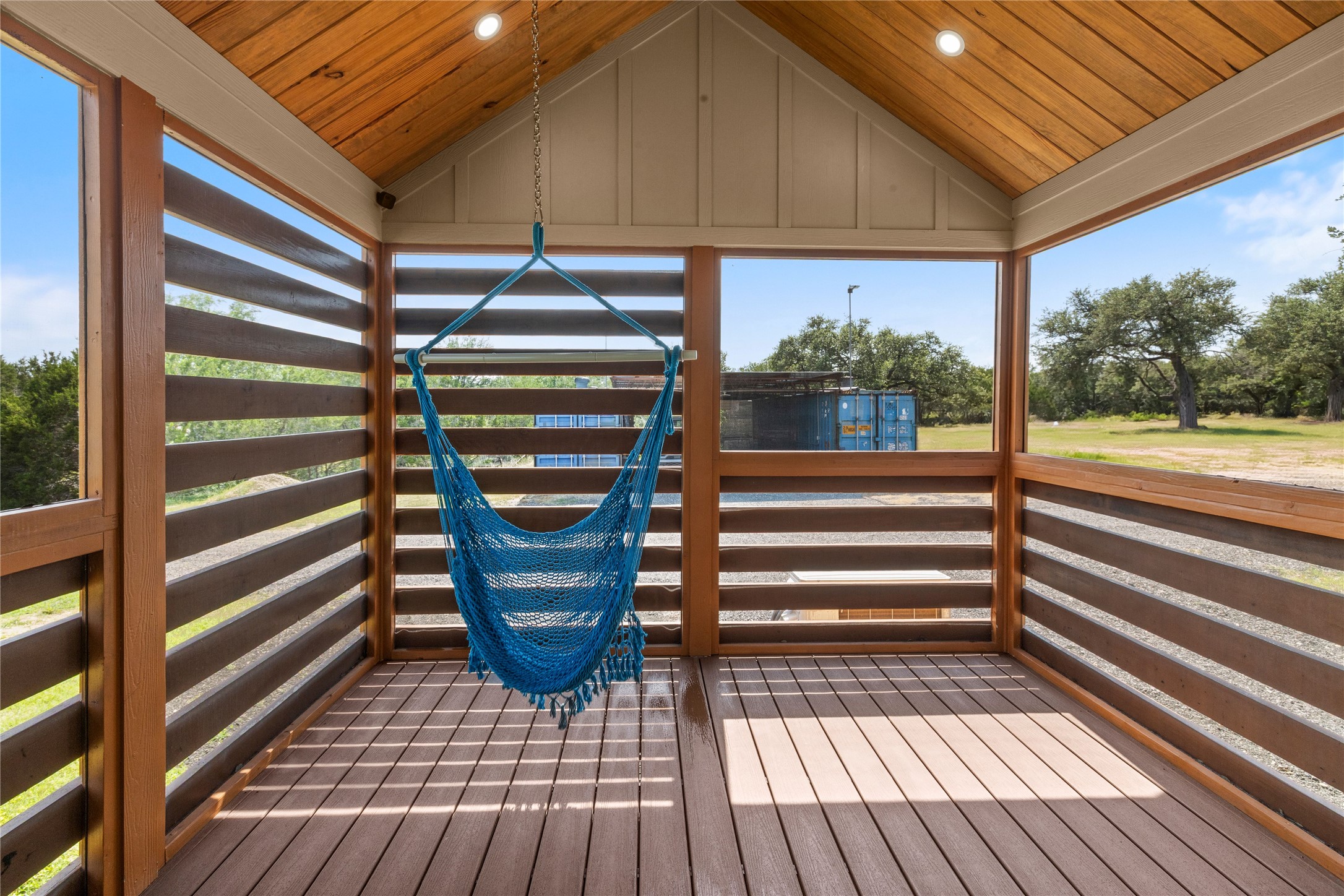 8200 Ranch Road 12 San Marcos, TX 78666 - Photo 12 of 40 A tranquil screened porch offers an inviting hammock and serene views of the surrounding natural landscape.
